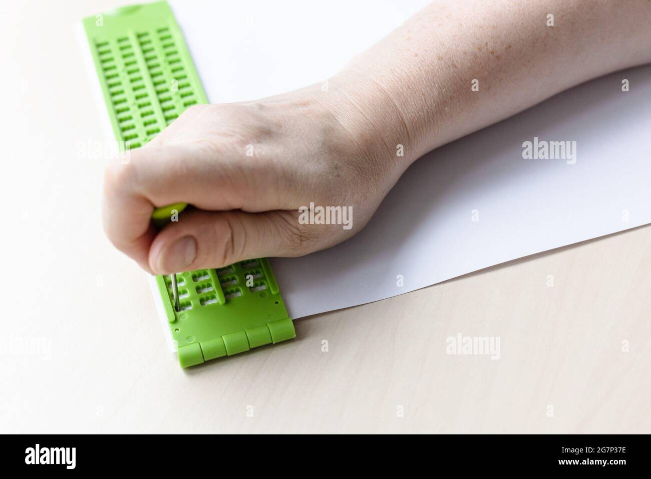 Schreiben von Wörtern in Braille-Schrift mit Schiefer und Eingabestift aus der Nähe Stockfoto