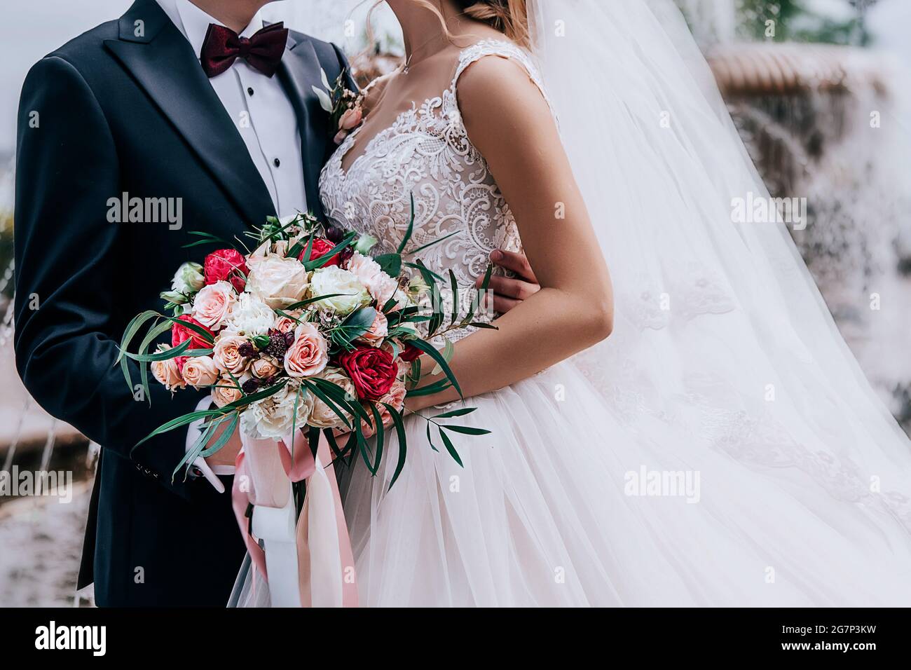 Schönes Paar mit einem erstaunlichen Brautstrauß aus roten, weißen, beigen Rosen Stockfoto