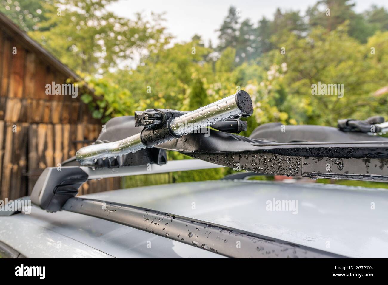 Dachgepäckträger auf einem silbernen Auto, Landschaft am Land im Hintergrund Stockfoto