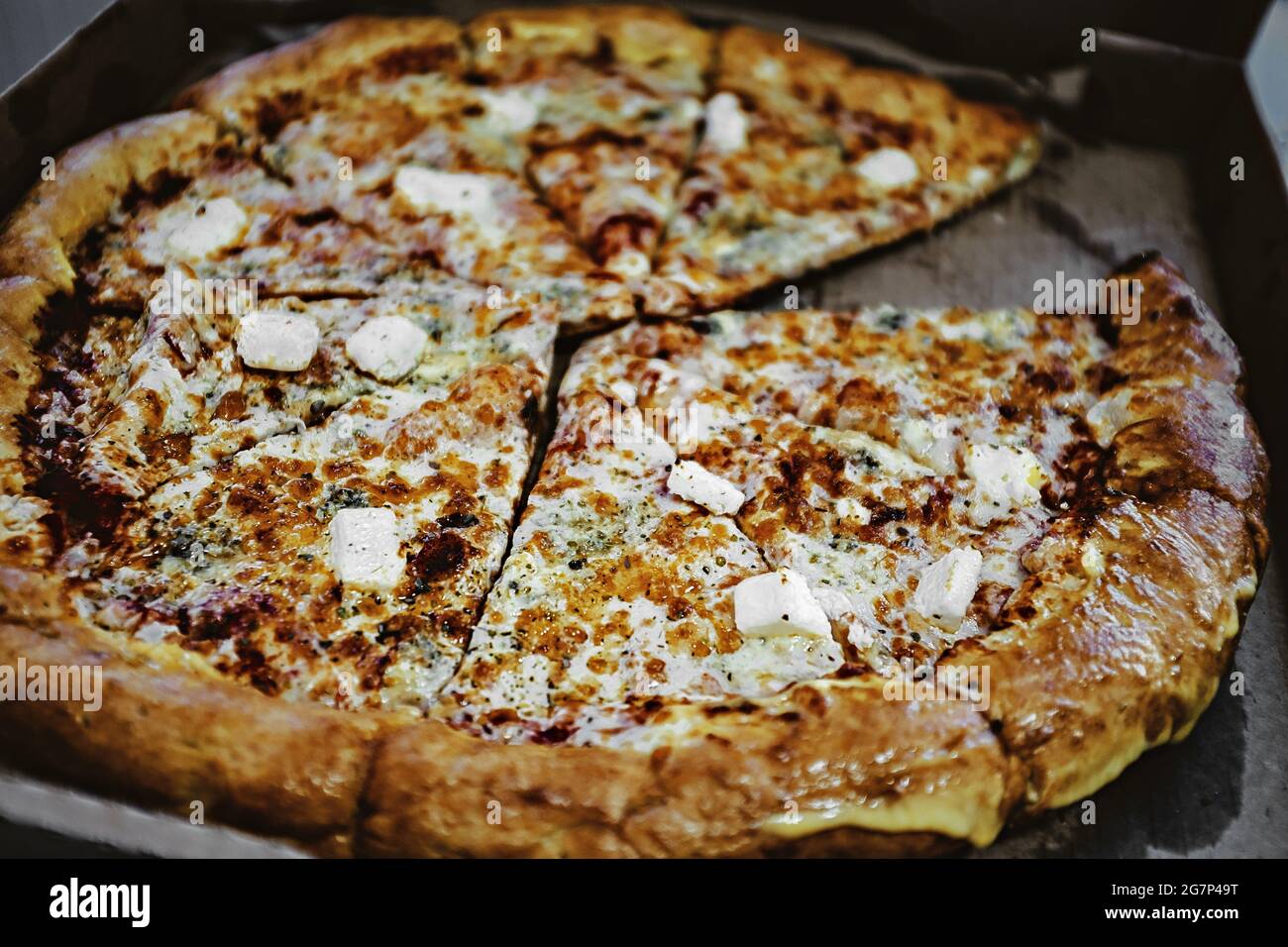 Pizza 'Four Cheese' in einer Pappschachtel. Leckere Pizza in Scheiben in einer Lieferschachtel. Frisch gebackene leckere Pizza isometrische Ansicht Stockfoto