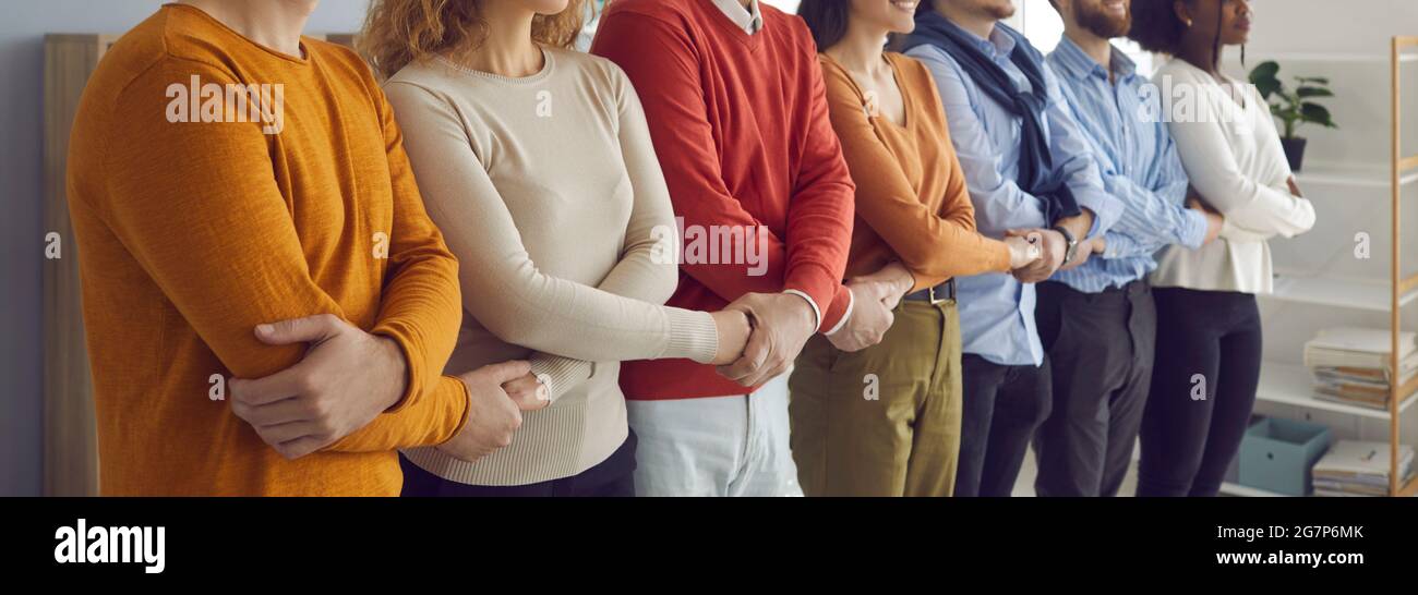 Freiberufliches Mitarbeiterteam, das die Hände in der Schlange zusammenhält Stockfoto