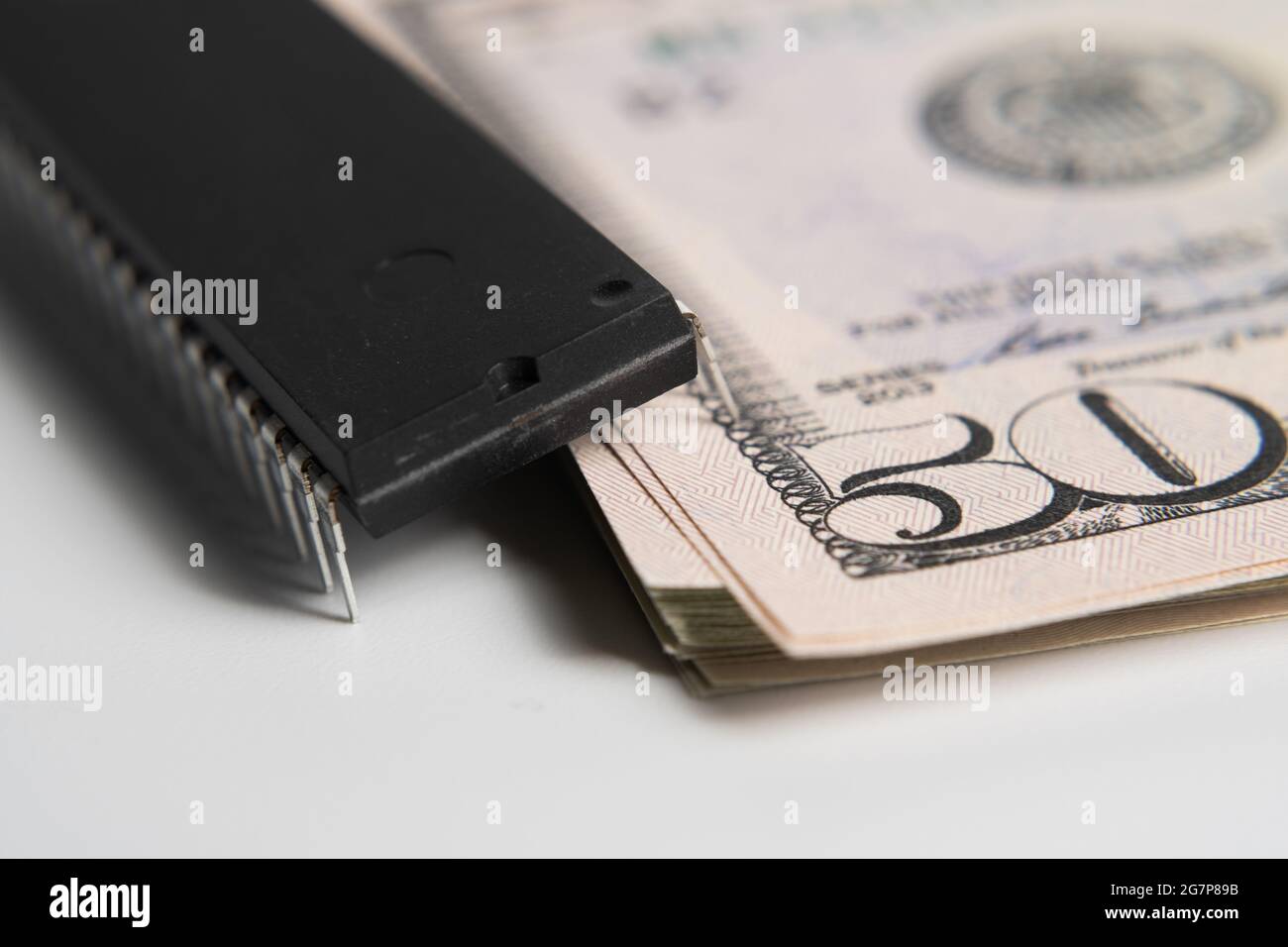 Großer Computerchip auf einem Stapel von 50 US-Dollar-Banknoten. Konzept für Investitionen in die Halbleiterindustrie und Golbal-Chipknappheit. Stockfoto