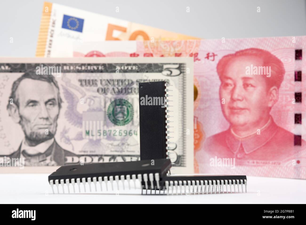 Mikrochips vorne und Banknoten wie 5 US-Dollar, 50 Euro und 100 Yuans. Konzept. Stockfoto