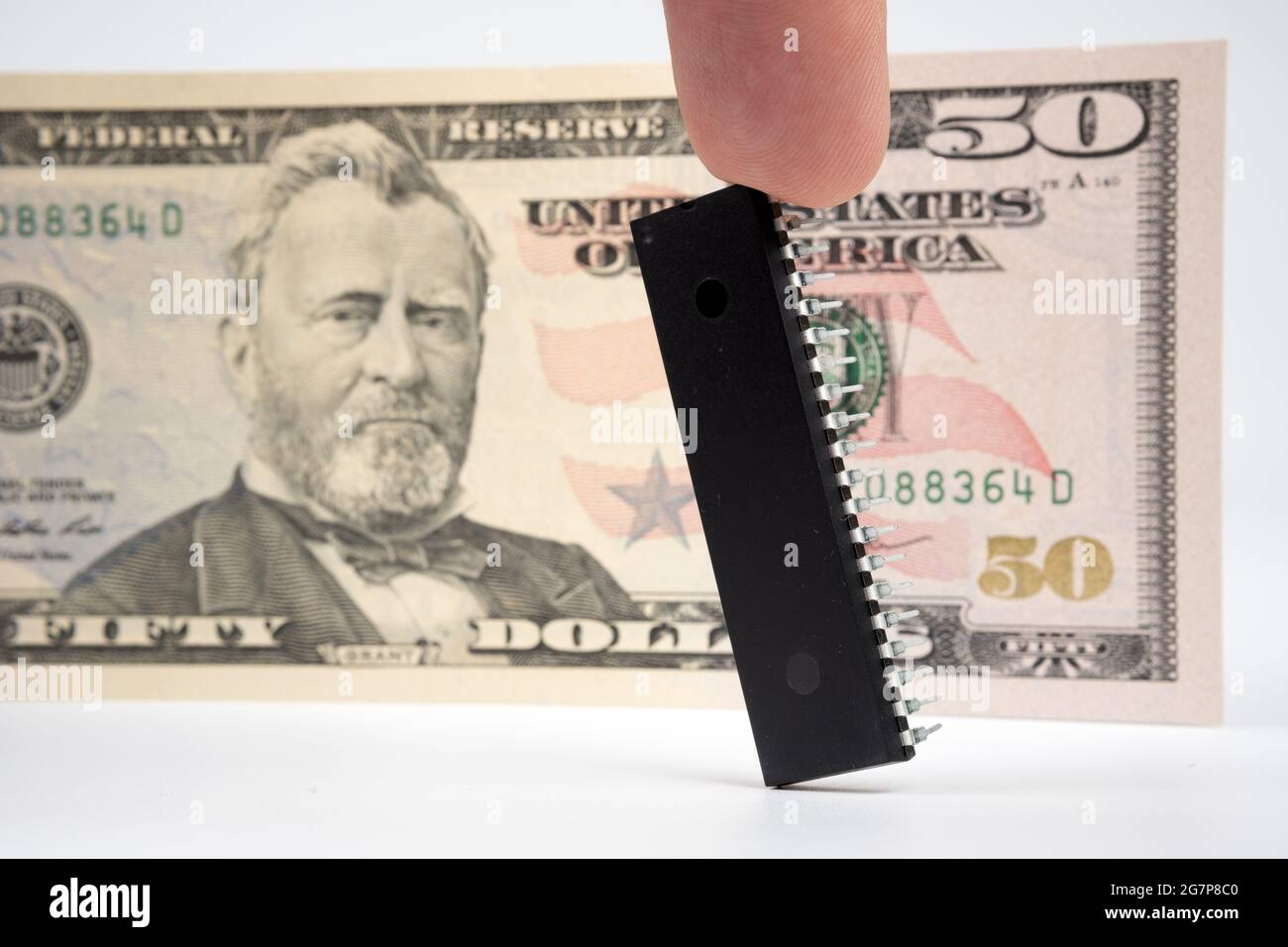 Großer Computerchip, der neben einer 50-US-Dollar-Banknote platziert wird. Konzept für Investitionen in die Halbleiterindustrie und Golbal-Chipknappheit. Stockfoto