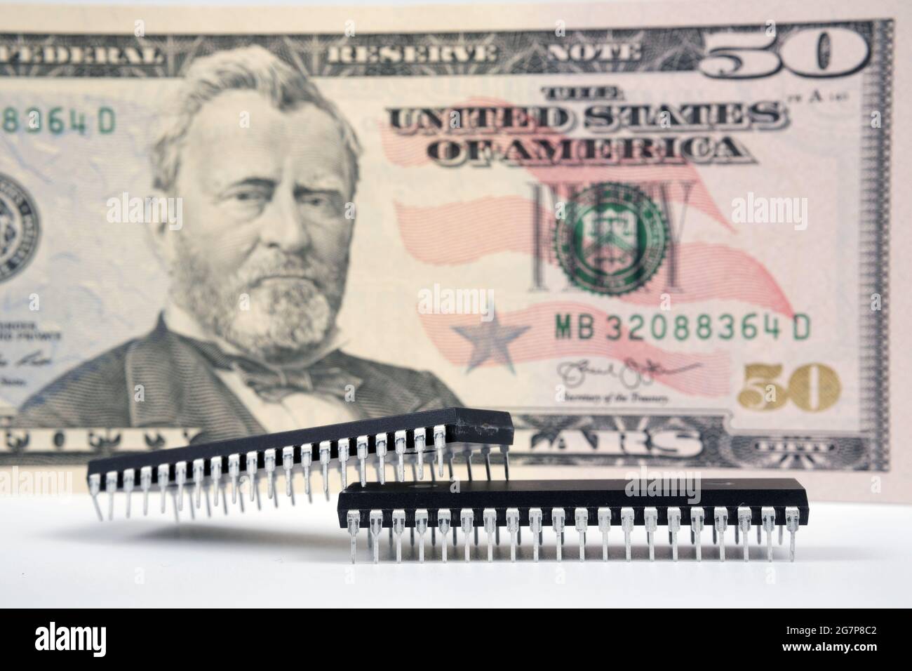 Große Computerchips, die neben einer 50-US-Dollar-Banknote platziert wurden. Konzept für Investitionen in die Halbleiterindustrie und Golbal-Chipknappheit. Stockfoto
