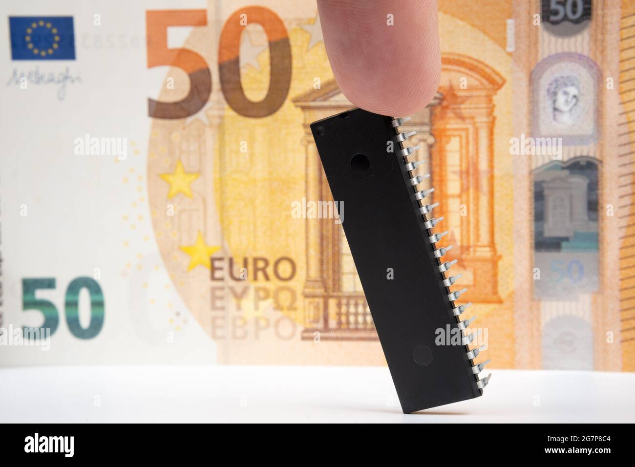 Großer Computerchip, der neben einer 50-Euro-Banknote platziert ist. Konzept für Investitionen in die Halbleiterindustrie und Golbal-Chipknappheit. Stockfoto