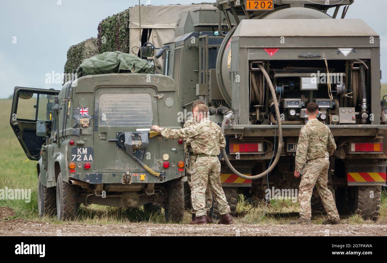 Britische Armee Land Rover Defender leichte Nutzfahrzeug mit einem M.A.N. Einheit unterstützen Fahrzeug Tanker auf Übung Salisbury Plain, Großbritannien Stockfoto