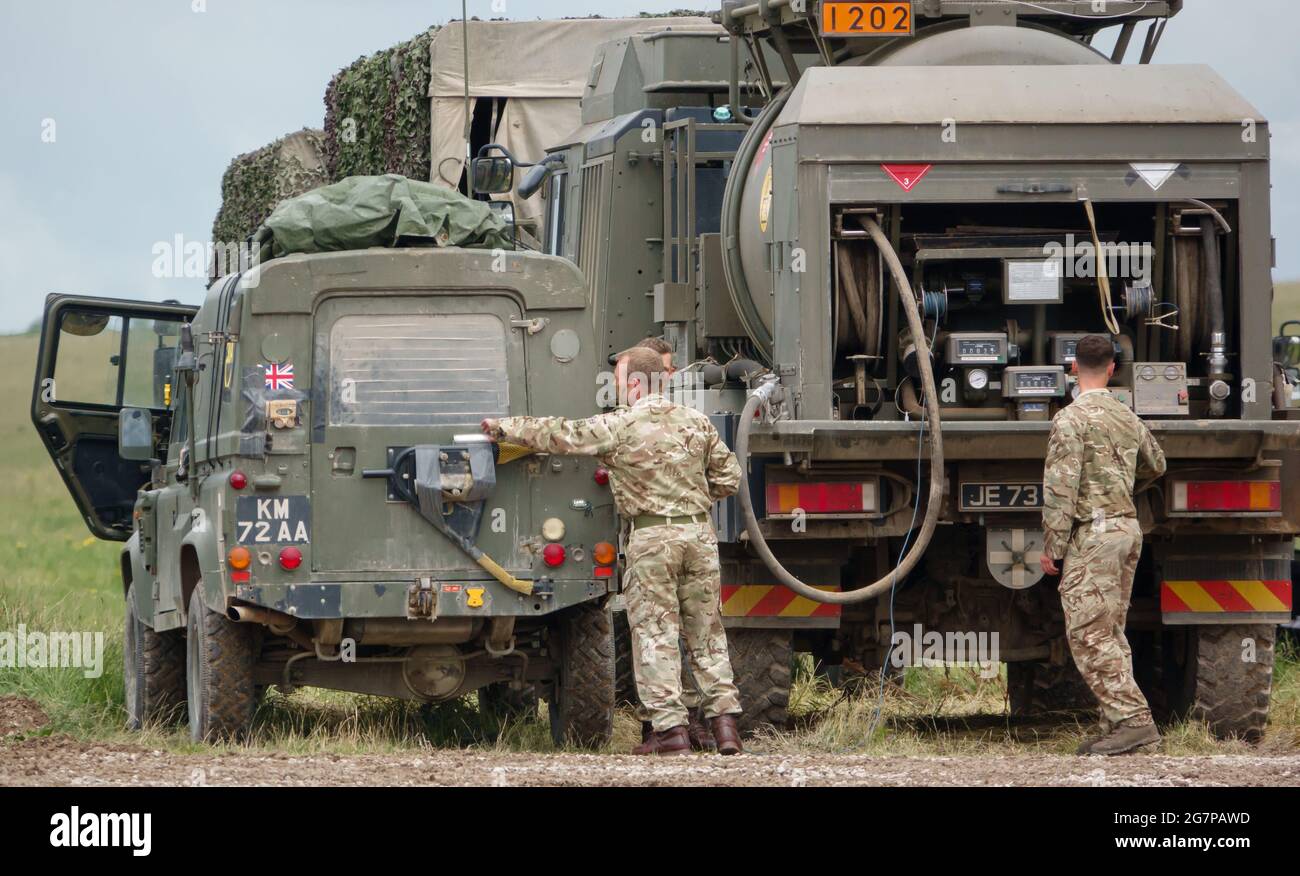 Britische Armee Land Rover Defender leichte Nutzfahrzeug mit einem M.A.N. Einheit unterstützen Fahrzeug Tanker auf Übung Salisbury Plain, Großbritannien Stockfoto