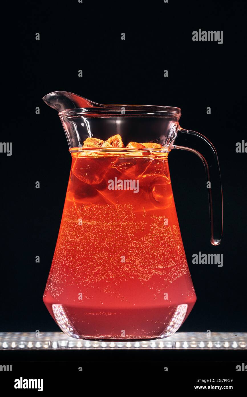 Glaskrug mit Limonade aus roter Erdbeere und Eis auf schwarzem Hintergrund Stockfoto