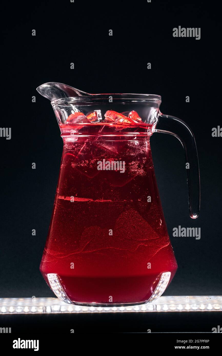 Glaskanne mit erfrischendem Limonade-Limonade oder Eis auf schwarzem Hintergrund Stockfoto