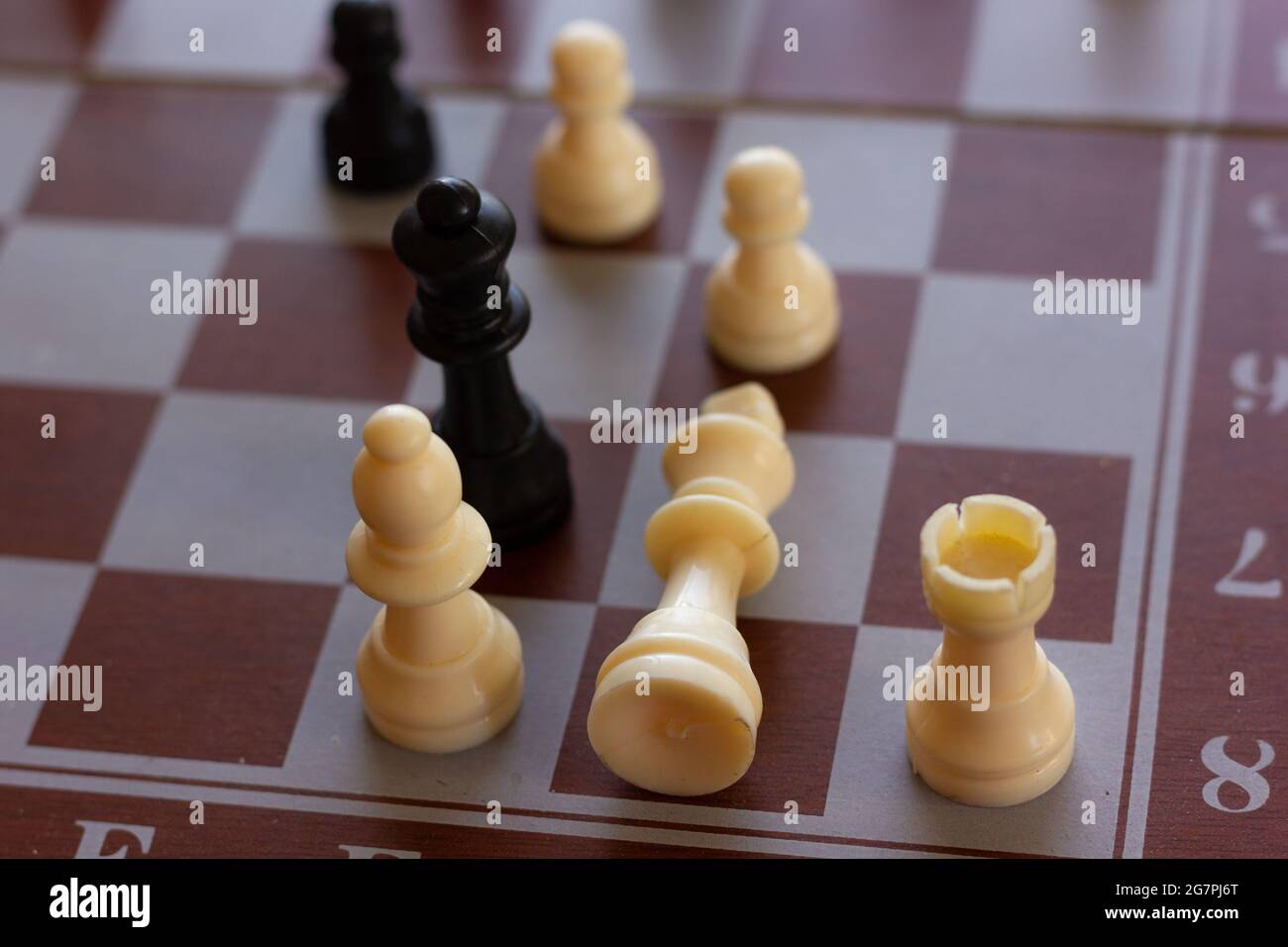 Weißes Königsstück, das aus Schachbrett liegt. Schachspiel, Strategie, Intelligenz, Sieg, Niederlage Konzepte Stockfoto