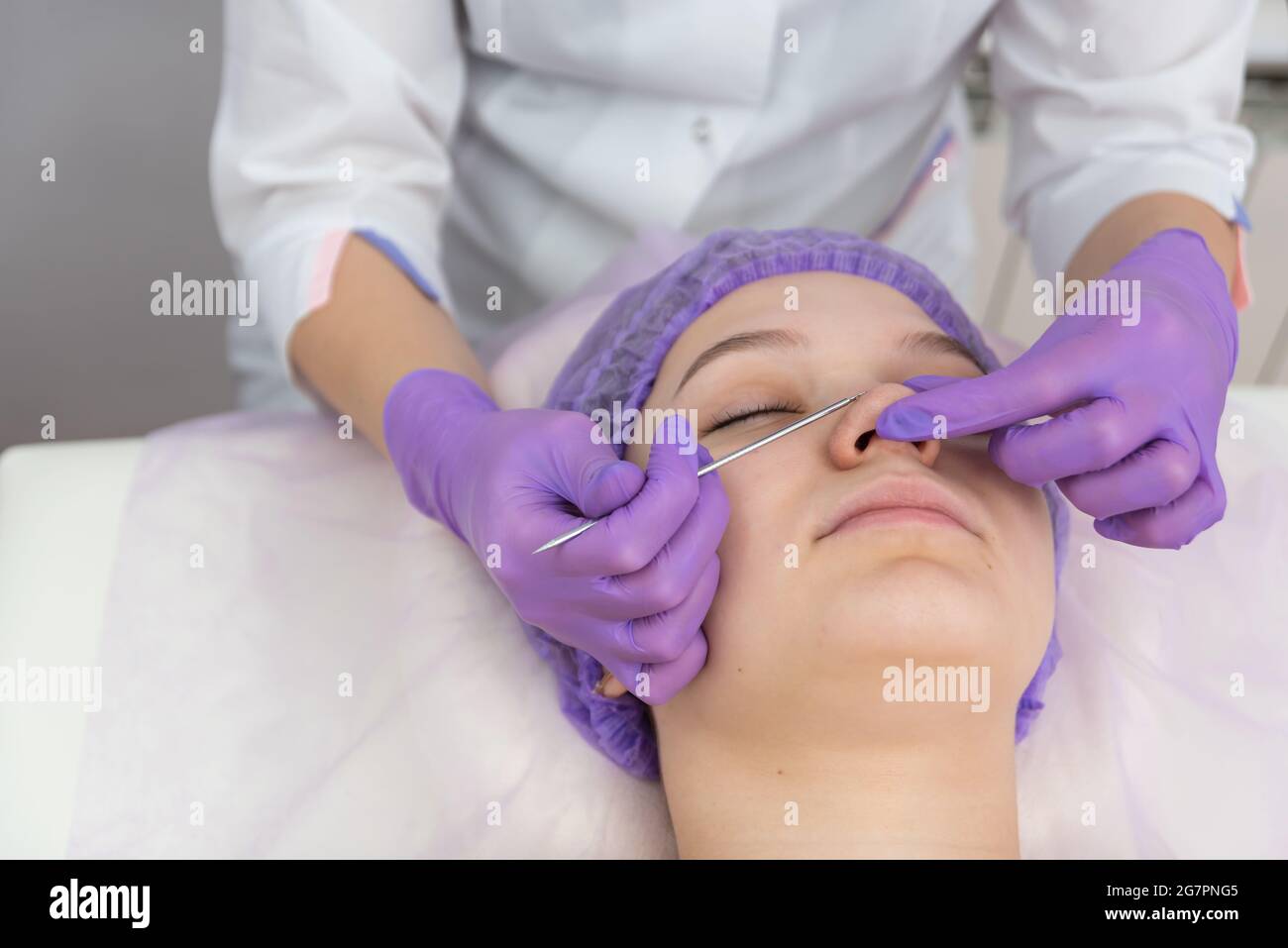 Weibliche Klientin hat eine Gesichtsbehandlung mit Hilfe der Augenschleife. Kosmetologie und Hautpflege Routine. Stockfoto