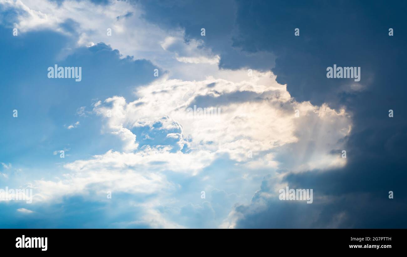 Blauer Himmel mit Wolken und Sonnenstrahlen Stockfoto