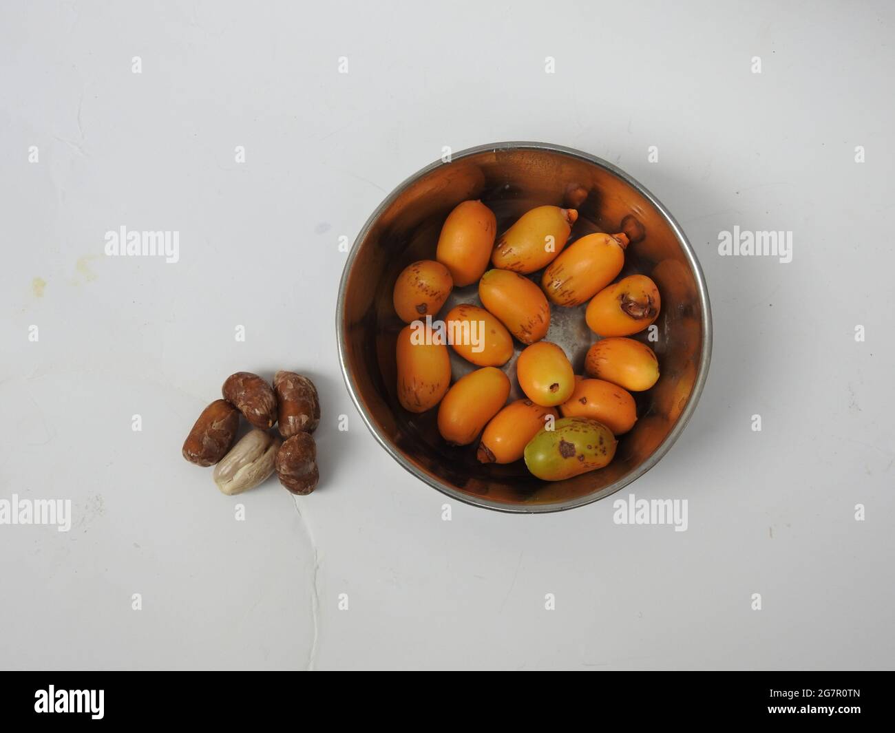 Teller mit rohen Zeidi-Datteln und Samen isoliert auf weißem Hintergrund Stockfoto