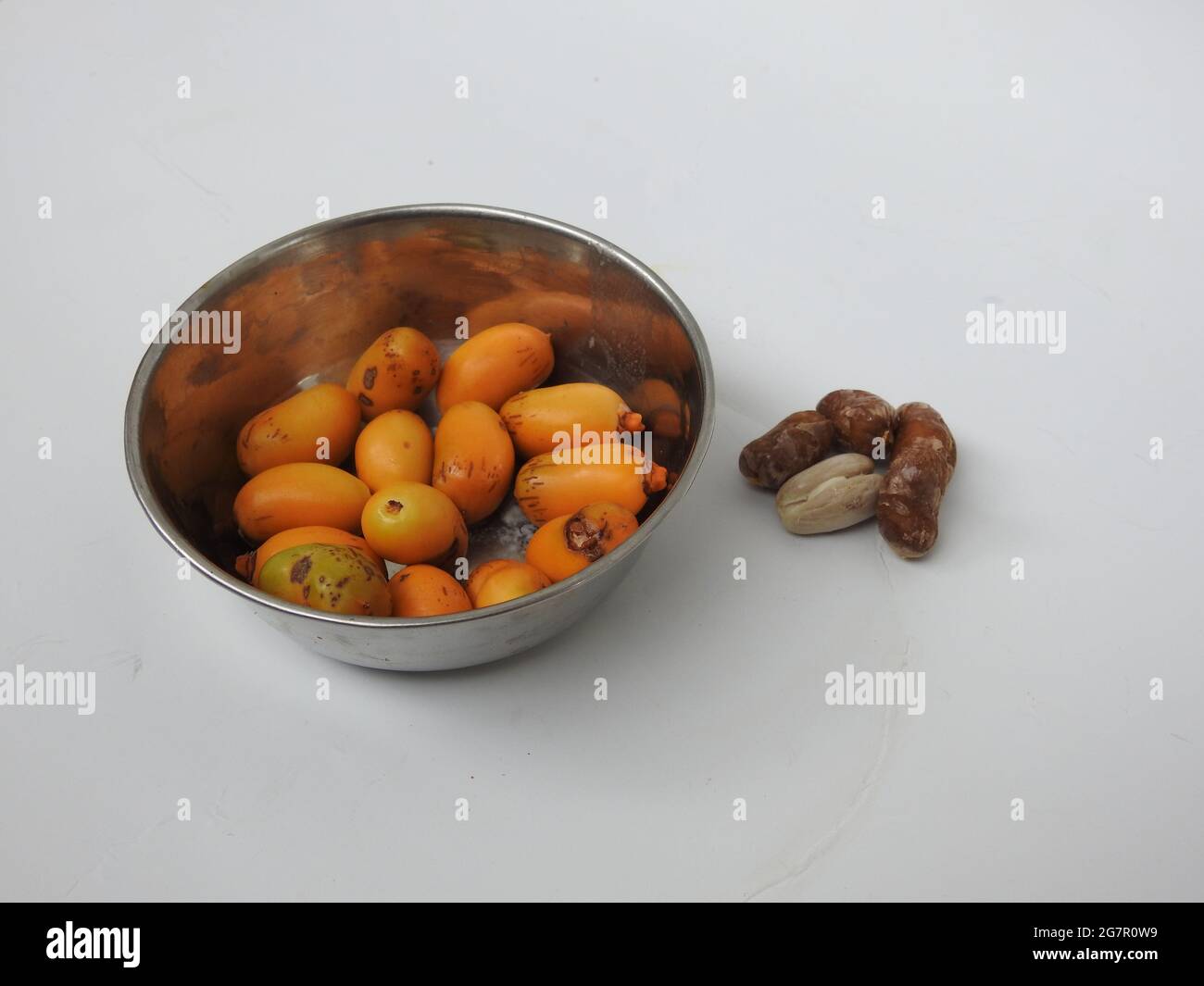 Teller mit rohen Zeidi-Datteln und Samen isoliert auf weißem Hintergrund Stockfoto