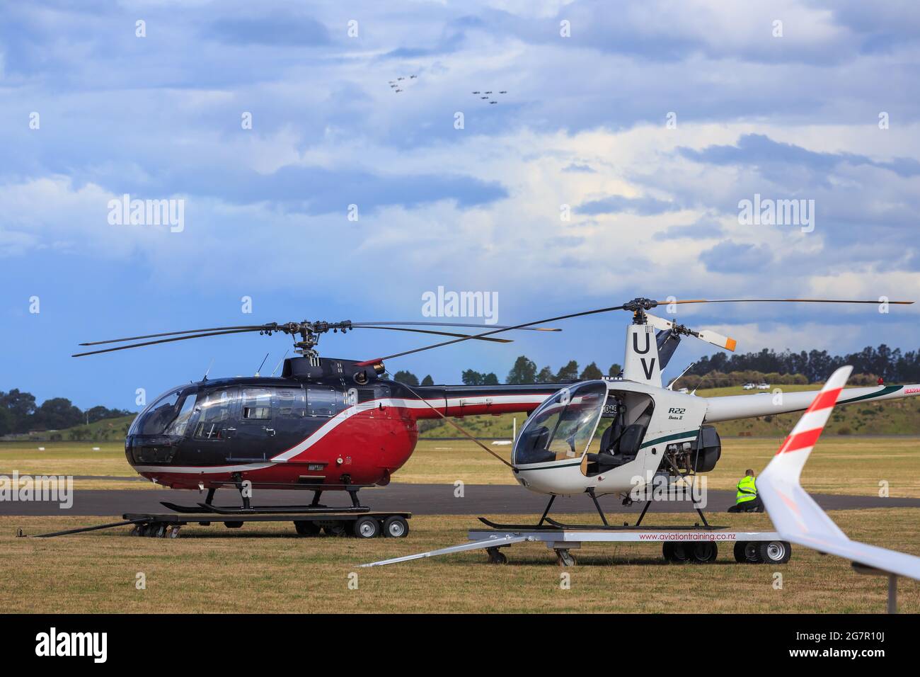 Zwei Hubschrauber, ein MBB Eurocopter BO105 und ein Robinson R22, auf Anhängern auf einem Flugplatz Stockfoto