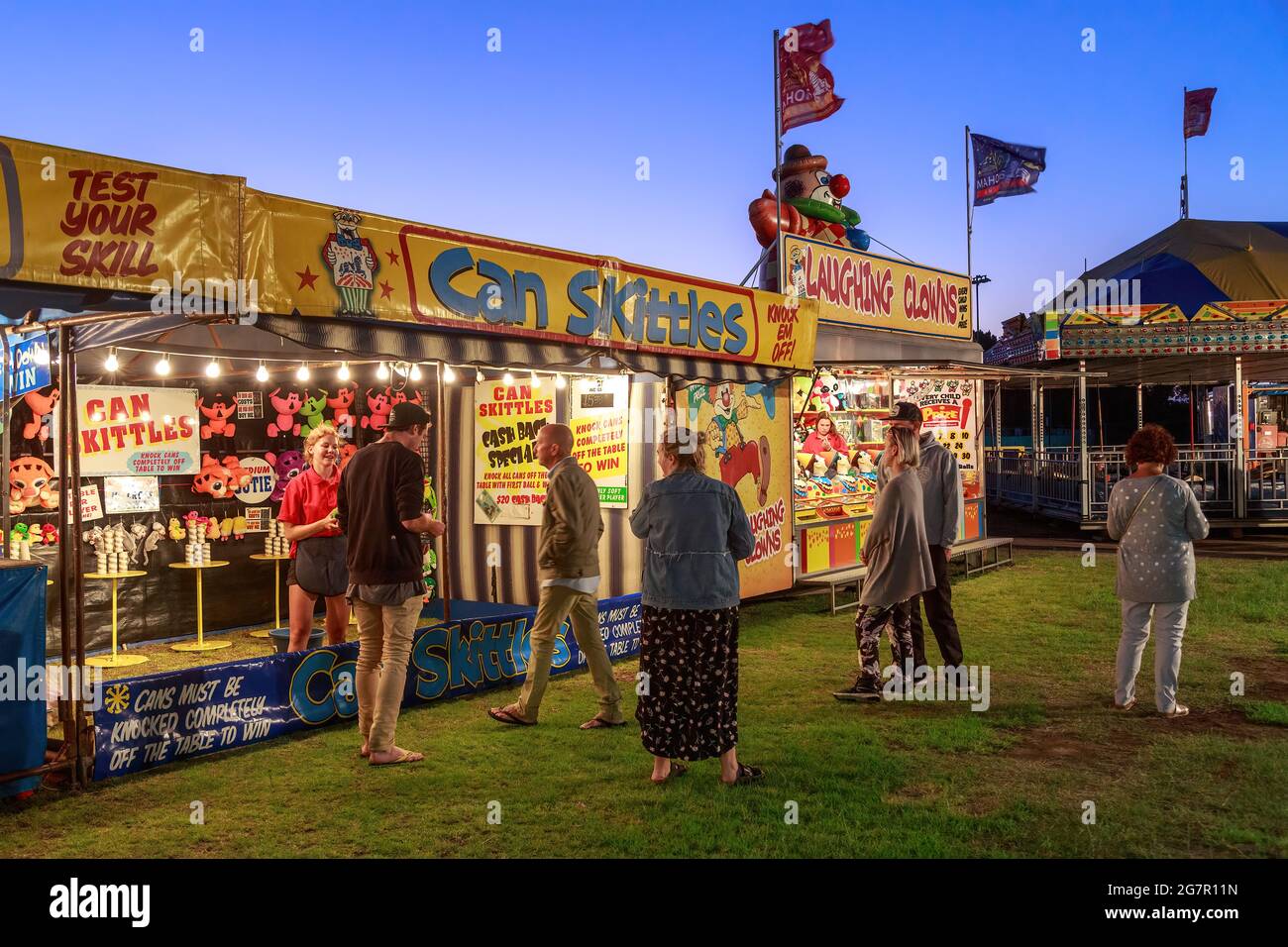 Sideshow-Spiele (Kegeln und „lachende Clowns“) bei einem nächtlichen Karneval in Mount Maunganui, Neuseeland Stockfoto