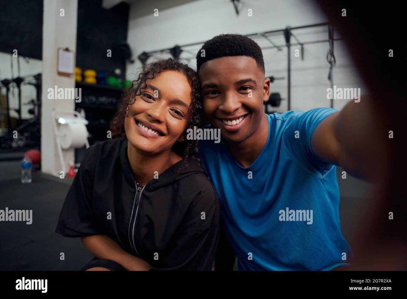 Gemischte Rennfreunde, die gemeinsam im Fitnessstudio ein Foto machen. Glücklicher afroamerikanischer Mann und Frau, die ein Selfie machen. Hochwertige Fotos Stockfoto