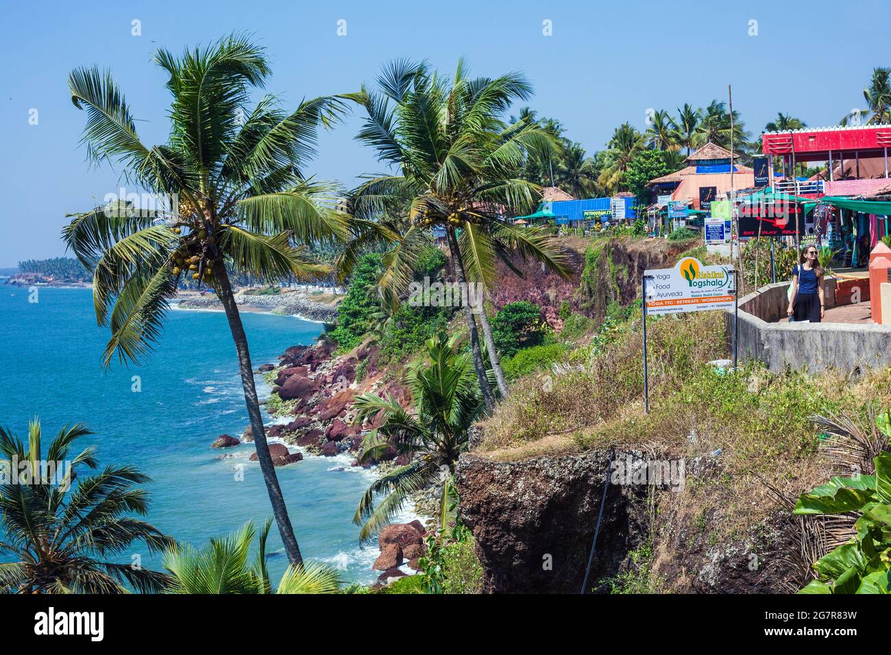 Palmen mit Kokosnüssen und einem Steg auf der Klippe mit Blick auf das Arabische Meer in Varkala, Kerala, Indien Stockfoto