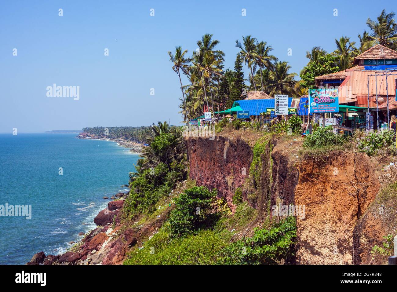 Palmen und Clifftop-Restaurants und Hütten mit Blick auf das Arabische Meer mit blauem Himmel in Varkala, Kerala, Indien Stockfoto