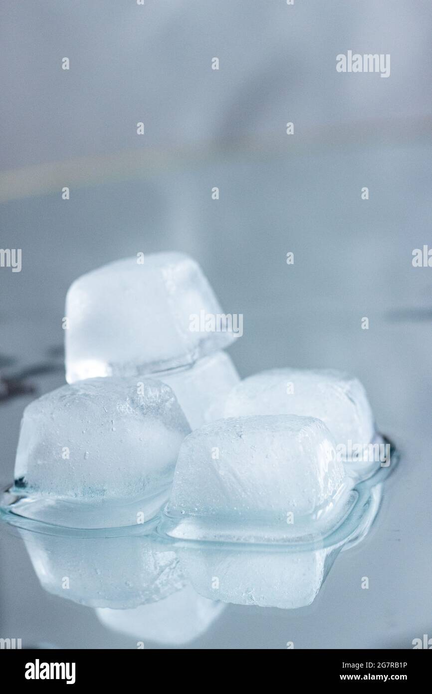 Stapel von Eiswürfeln mit Spiegelung; Eiswürfel schmelzen; erfrischende Getränke; kühlendes Wasser; sommerliche Erfrischung Stockfoto