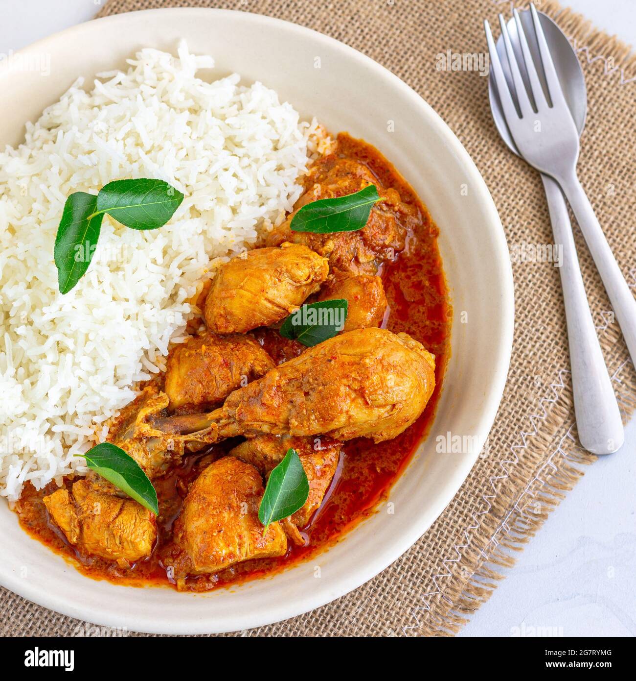 Huhn Curry garniert mit Curry Blätter Top Down Horizontales Foto auf weißem Hintergrund Stockfoto