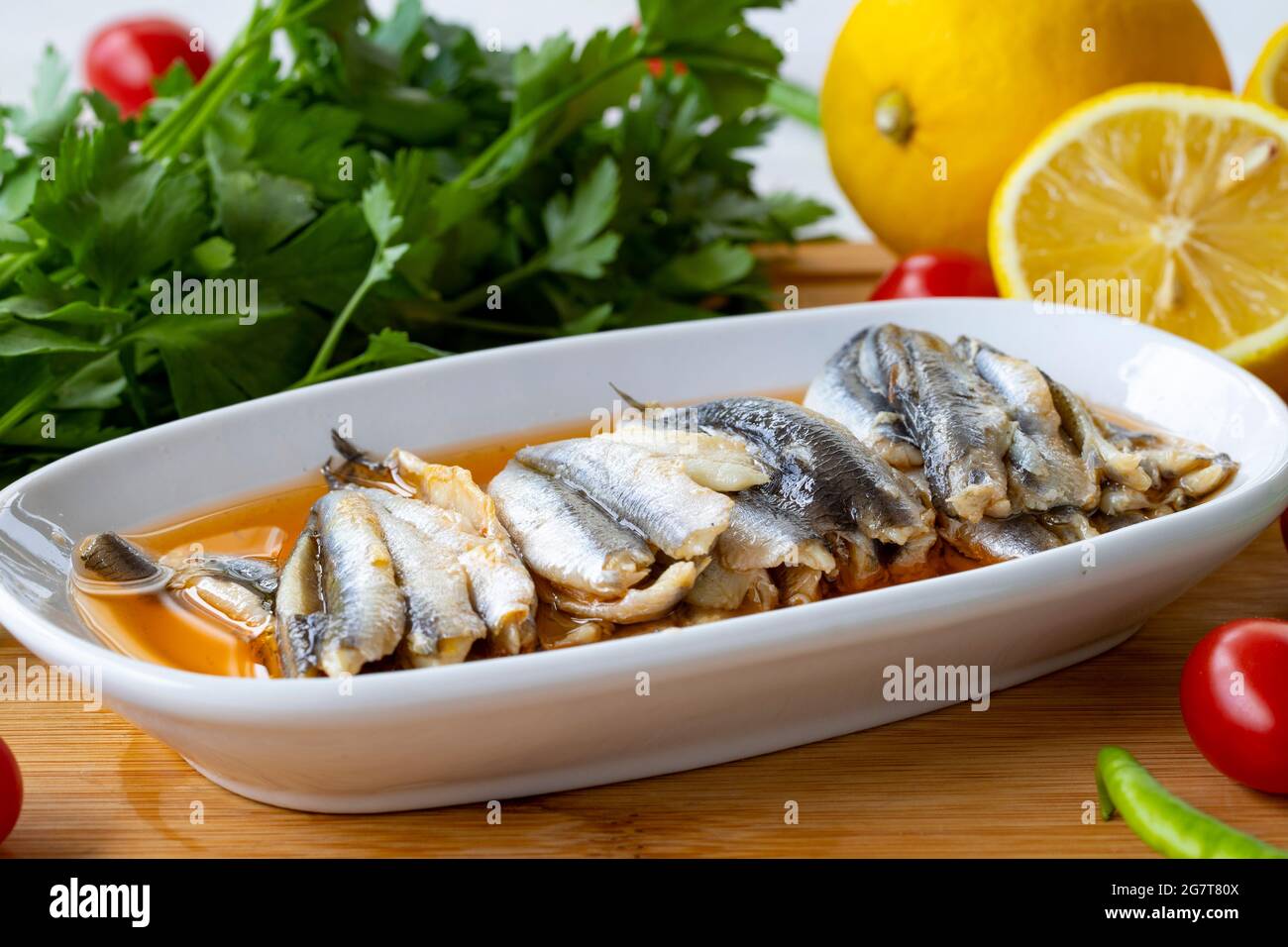 Marinierte Sardellen auf Holzgrund. Fischgerichte Stockfoto