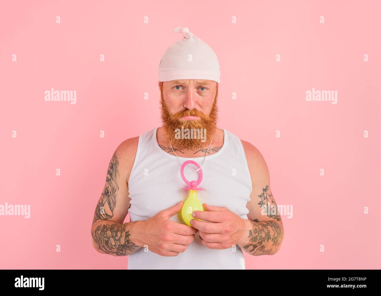 Wahnvorstellung Mann mit Bart und Tattoos wirkt wie ein kleines Neugeborenes Stockfoto