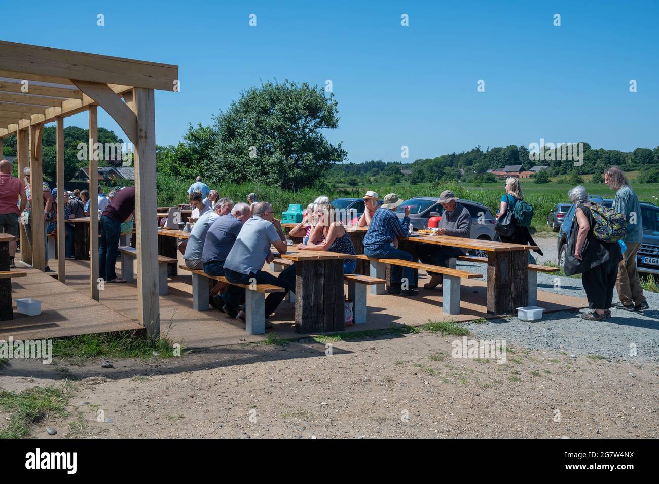 Blick auf das lokale Fish and Chip Restaurant am Dunwich Beach mit vielen Leuten, die an einem sonnigen Sommertag draußen sitzen und essen und trinken Stockfoto