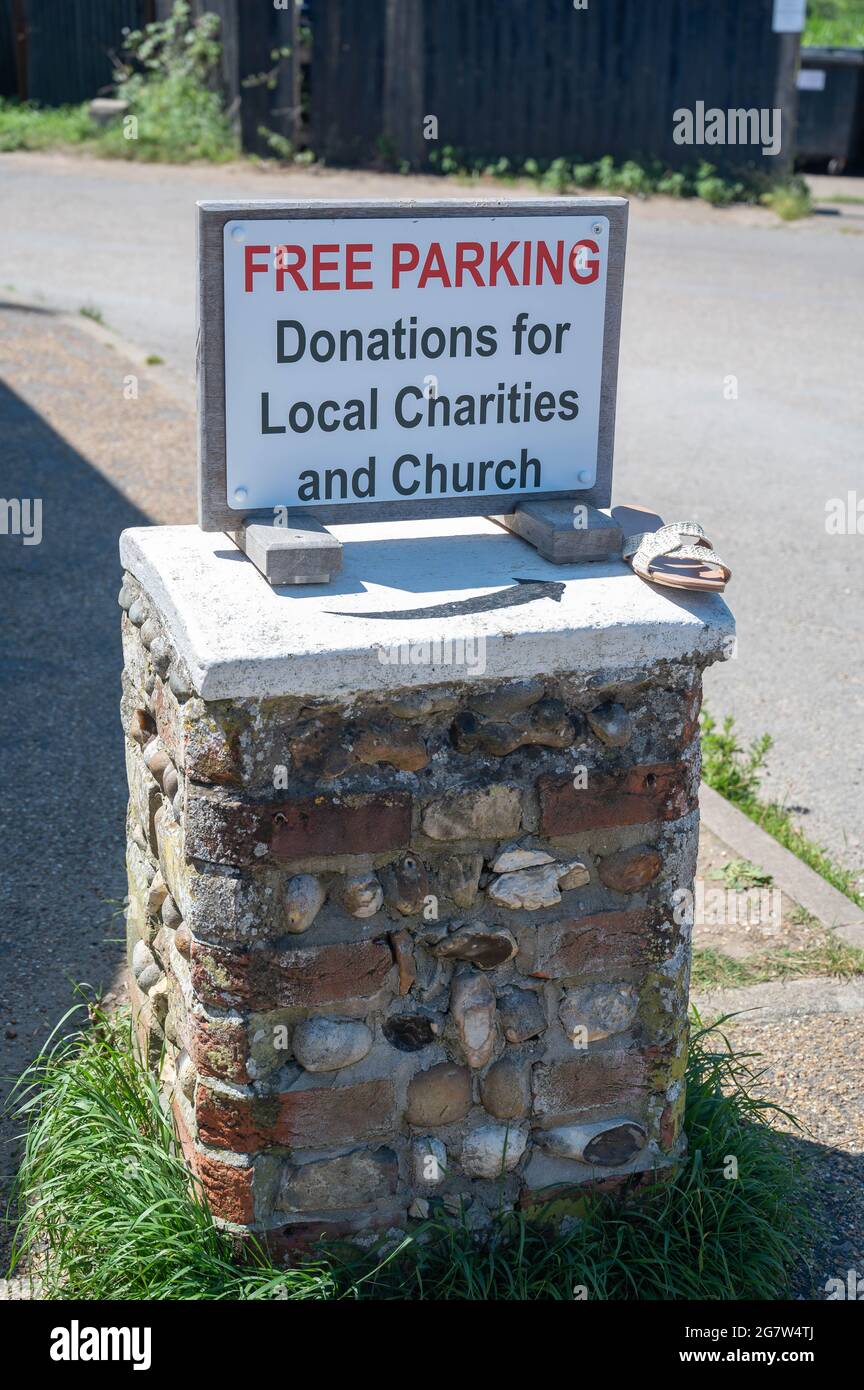 Eine Spendenbox für den Parkplatz für die örtliche Kirche und Wohltätigkeitsorganisationen aus Steinen am Strand von Suffolk Stockfoto