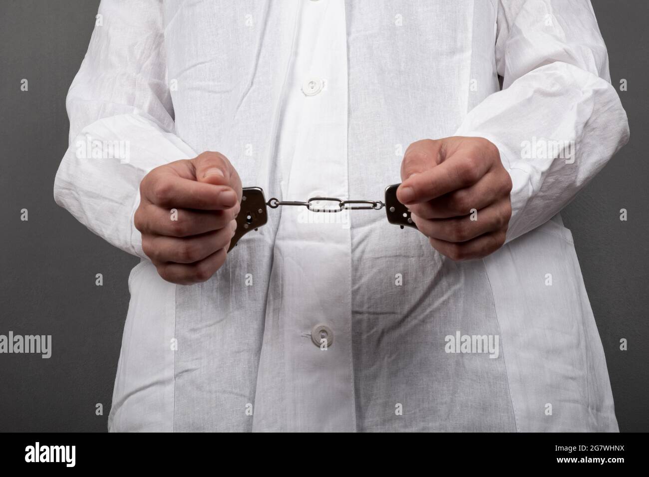 Der Arzt mit Handschellen beging ein Verbrechen und verhaftete ihn wegen des Verkaufs illegaler Drogen. Stockfoto