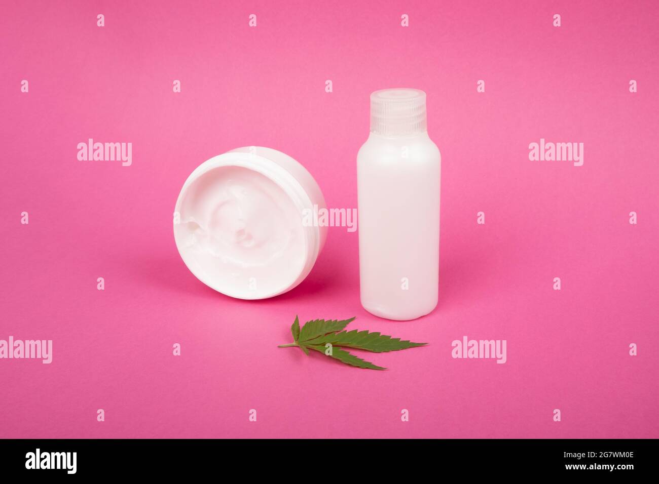 Körperpflege, Anti-Aging Hautpflegekosmetik mit Marihuanaextrakt auf rosa Hintergrund. Stockfoto