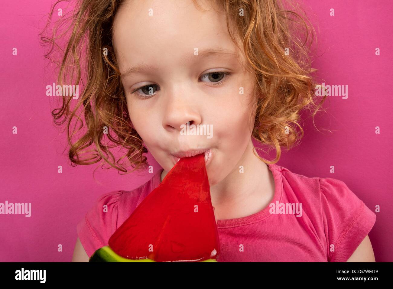 Kleines Mädchen, das Wassermelonen-Süßigkeiten isst, lieben Kinder Süßigkeiten. Stockfoto