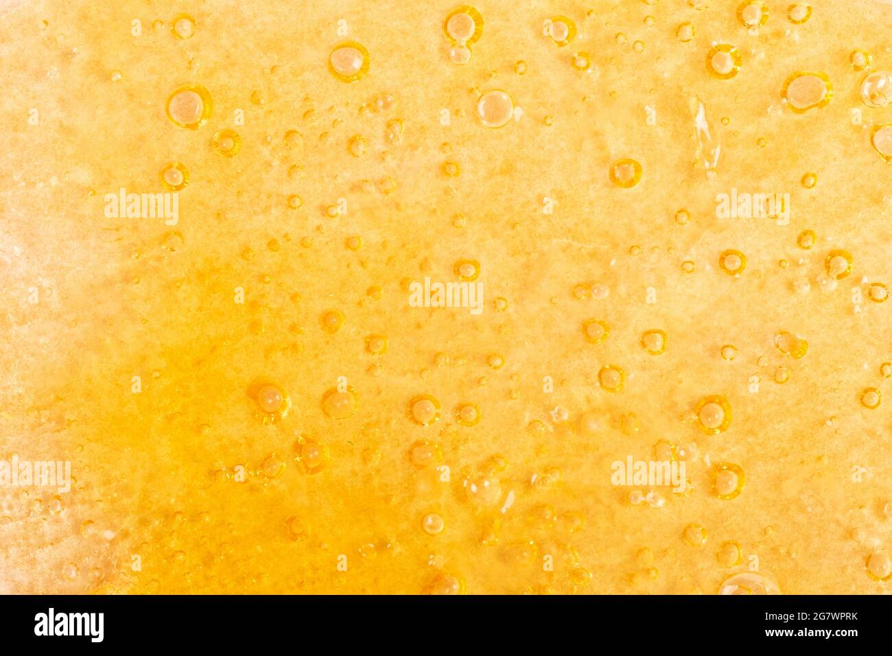 goldener Hintergrund von Marihuana-Wachs-Nahaufnahme, Cannabis-Tupfer-Textur. Stockfoto