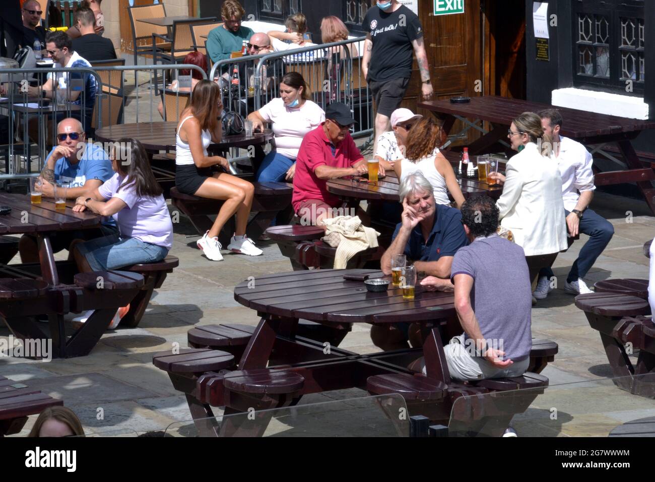 Die Menschen genießen die Sommersonne, wenn sie in einem Pub im Zentrum von Manchester, England, im Freien sitzen. Stockfoto