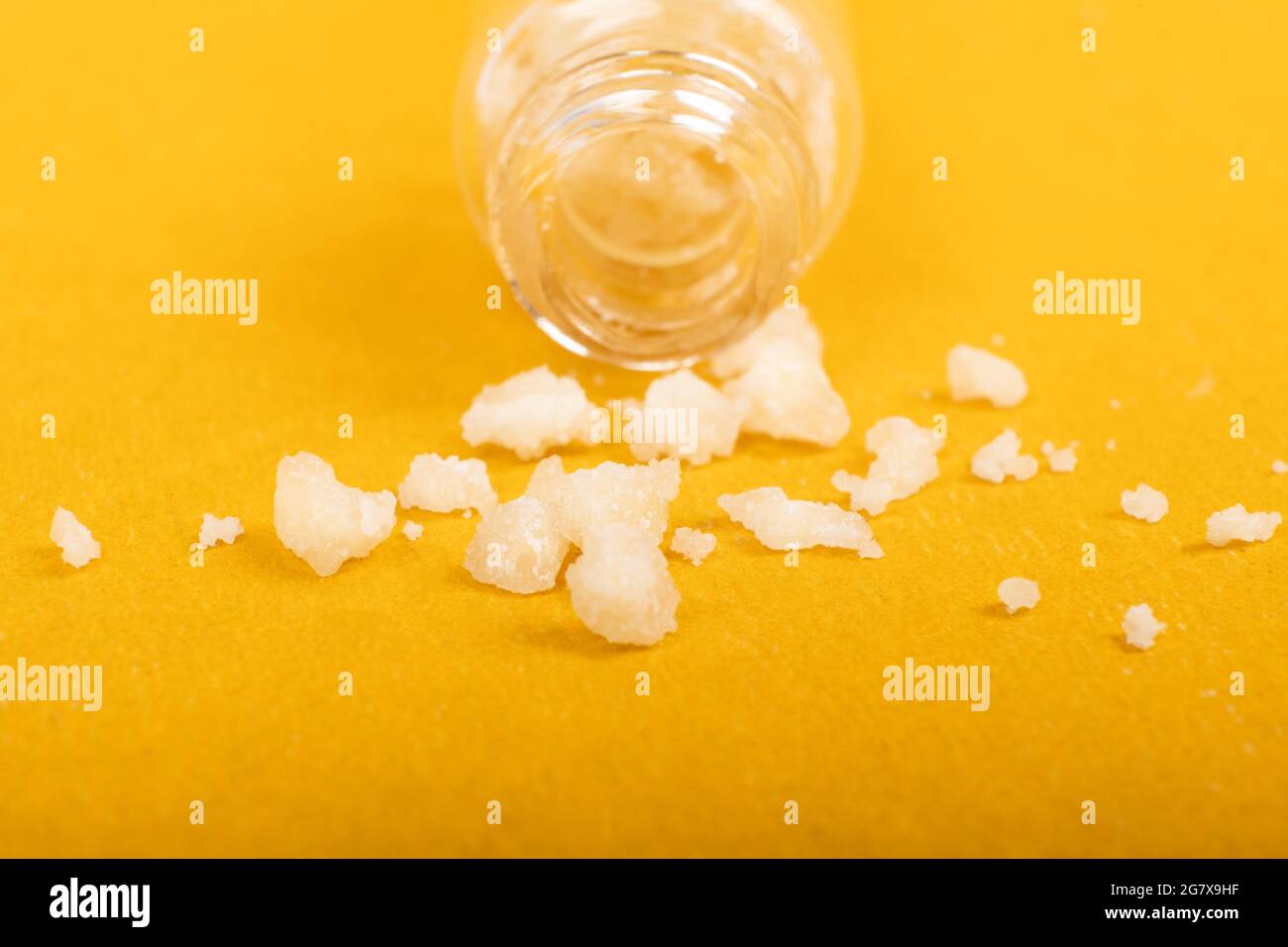 Crystal Mephedron Designer Drogen, Badesalz auf gelbem Hintergrund. Stockfoto