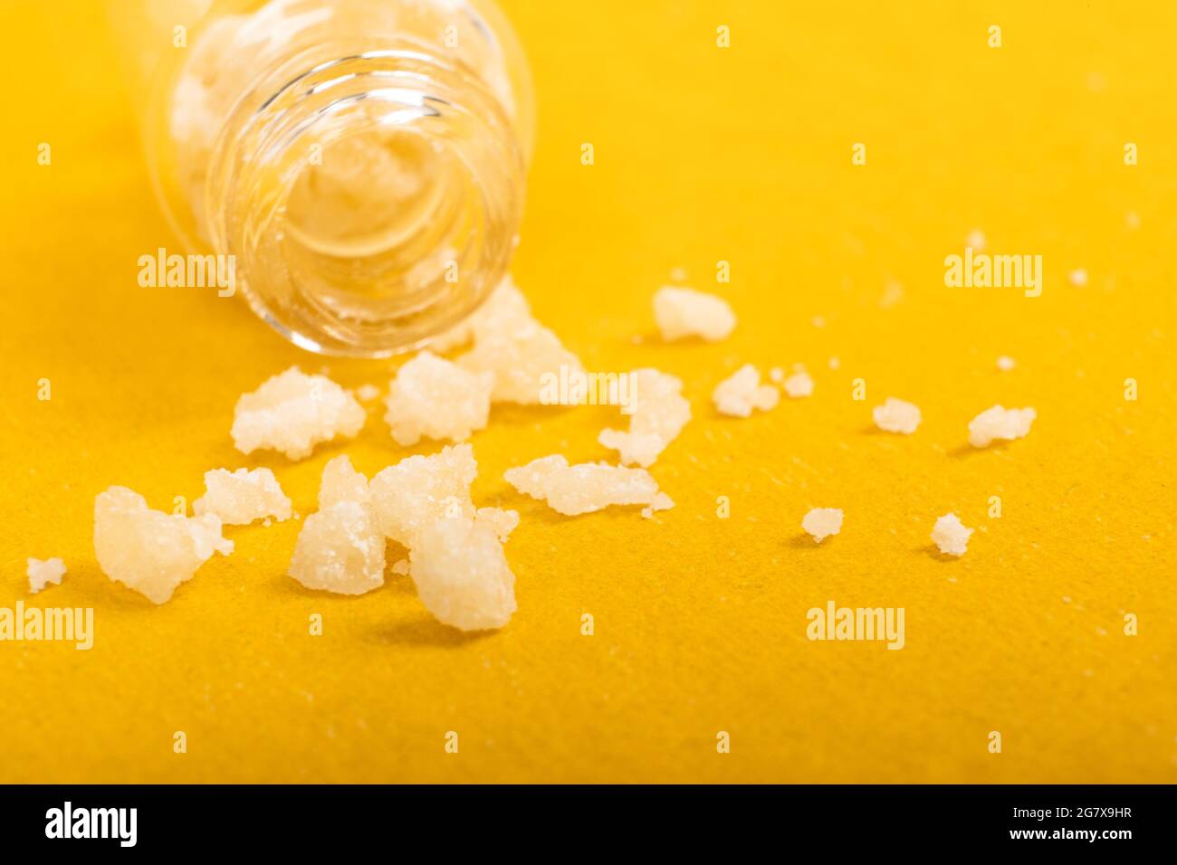 Narkotische Salzkristalle Amphetamin auf gelbem Hintergrund. Stockfoto