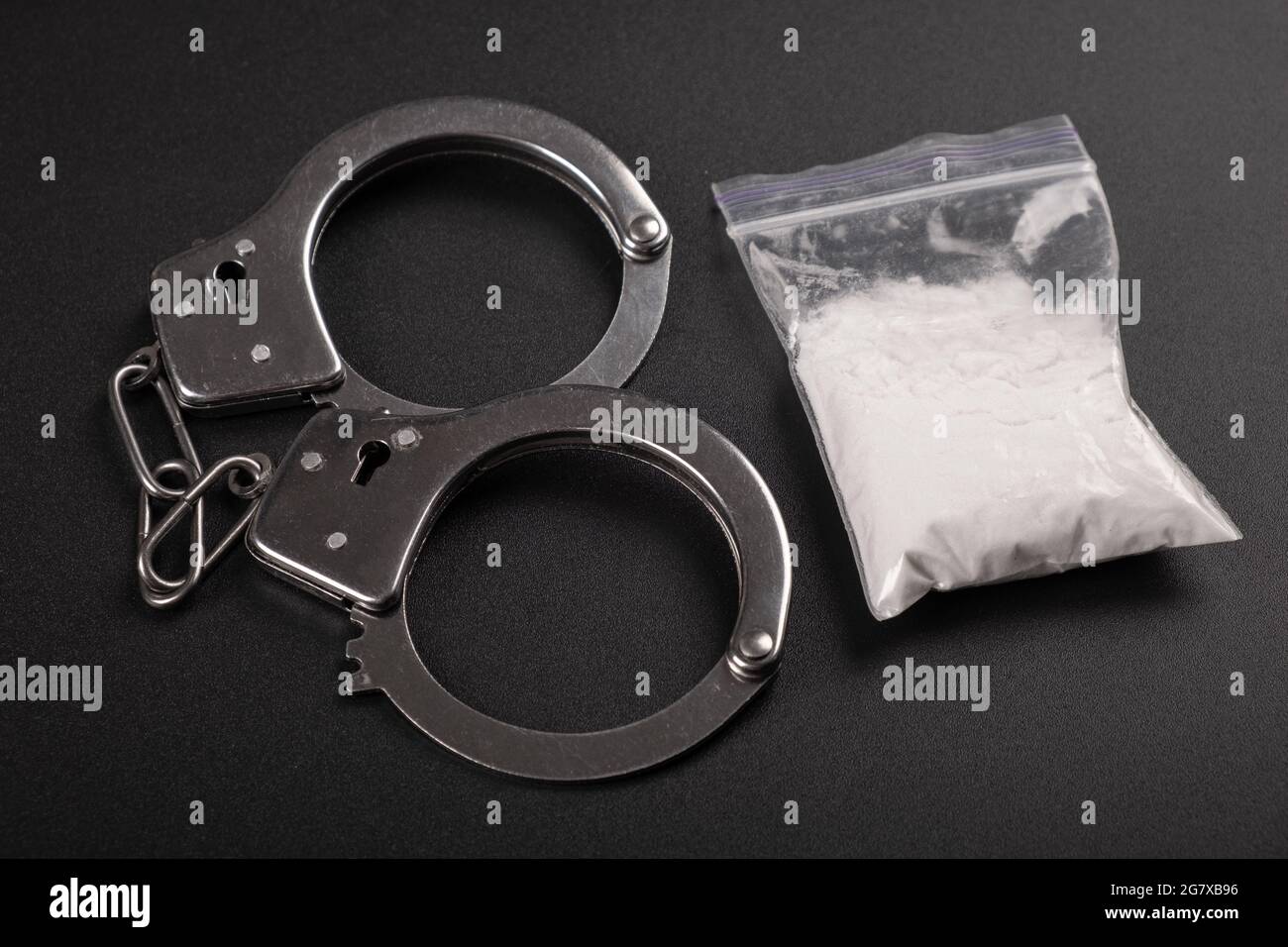 Drogenstrafung, Handschellen und weißes Kokain-Pulver Draufsicht. Stockfoto