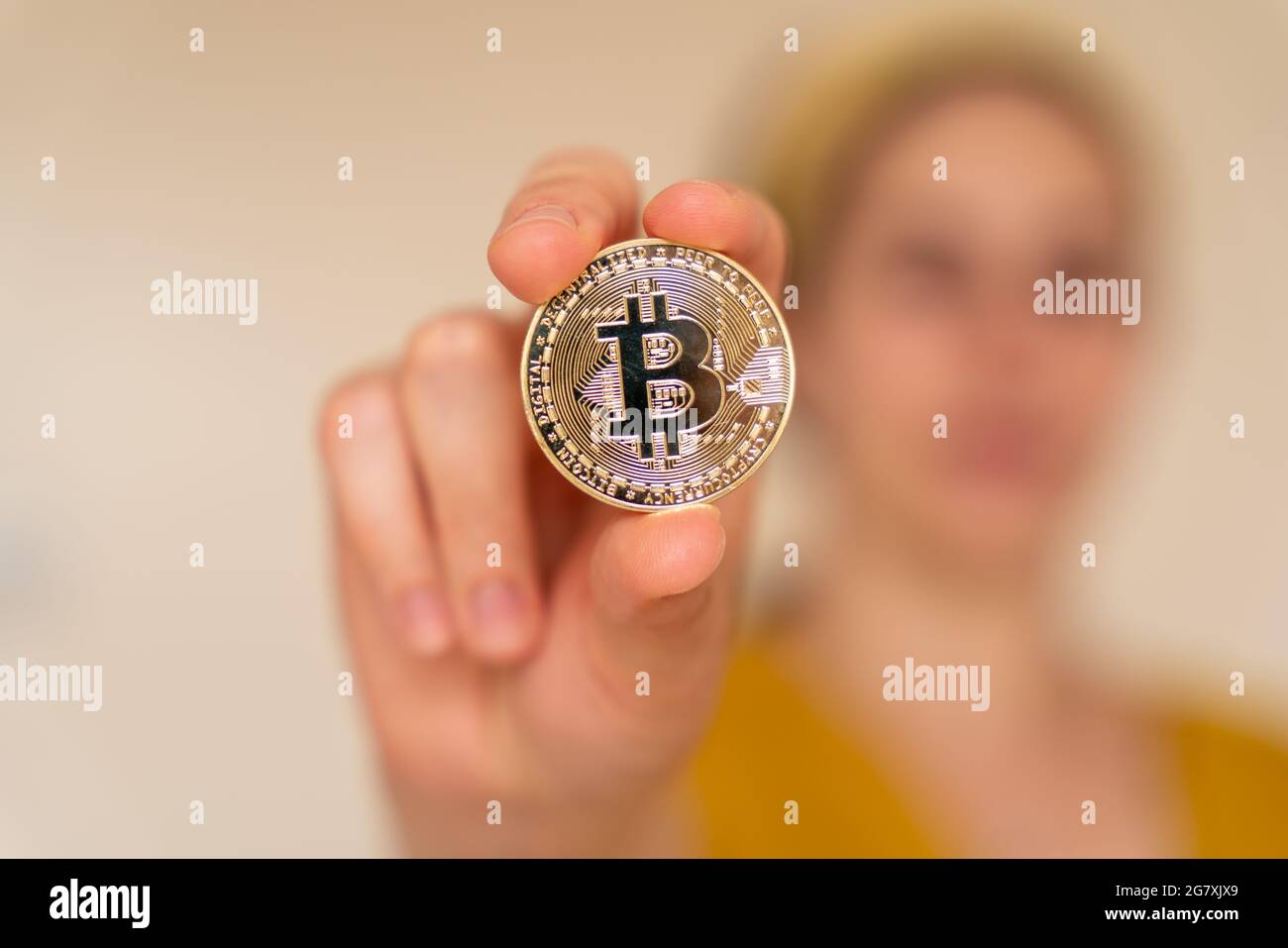 Nahaufnahme einer Frau, die Bitcoin-Kryptowährungsmünze in der Hand hält Stockfoto