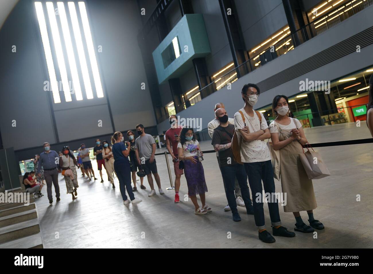 In einem NHS-Pop-up-Impfzentrum in der Tate Modern Art Gallery in London stehen Menschen für ihre Impfungen in der Schlange. Siehe PA Geschichte GESUNDHEIT Coronavirus. Bildnachweis sollte lauten: Kirsty O'Connor/PA Wire Stockfoto