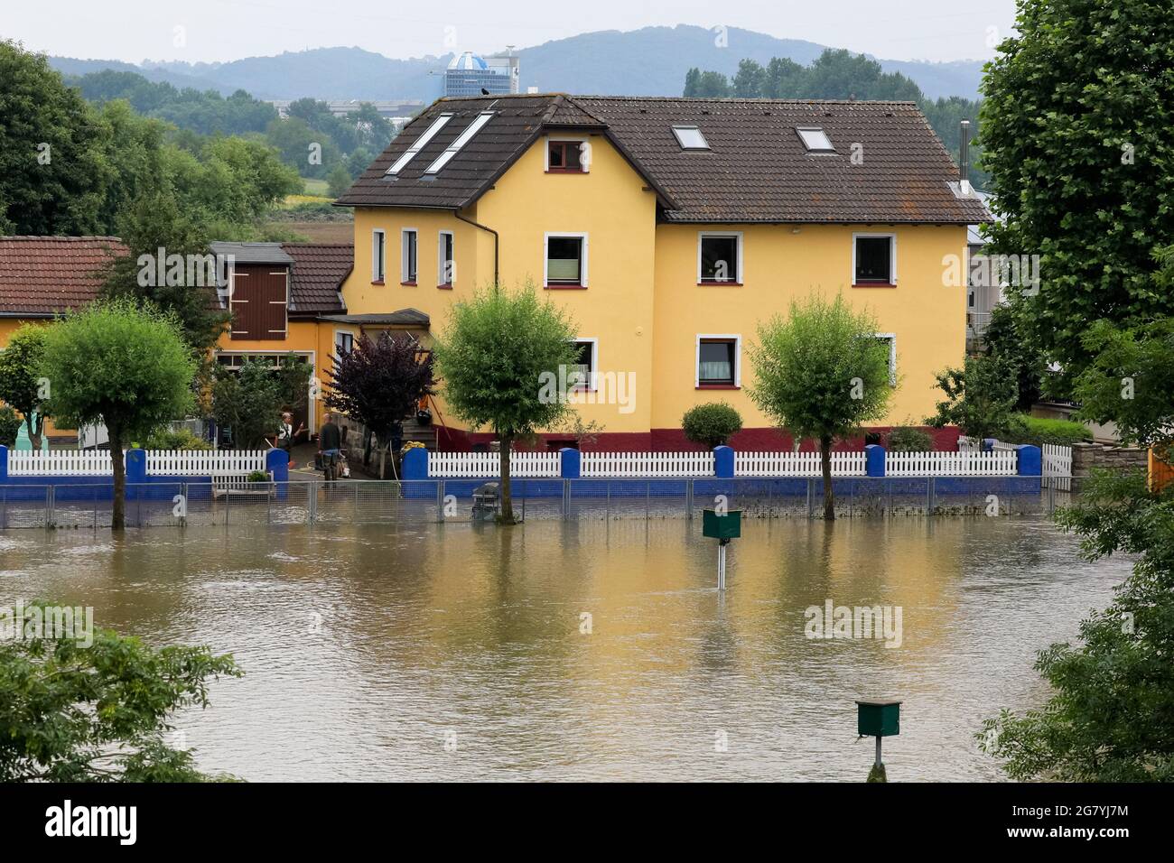 Hattingen, NRW, Deutschland. Juli 2021. Ein Anwesen am Fluss ist von Wasser umgeben. Die Ruhr hat ihre Böschung, Felder und viele Gärten, Keller und Grundstücke in der Nähe der Stadt Hattingen im Ruhrgebiet in Nordrhein-Westfalen überflutet. NRW ist nach starken Regenfällen in den letzten Tagen von schrecklichen Überschwemmungen heimgesucht worden. Bei den Überschwemmungen in Deutschland sind bisher mehr als 80 Menschen ums Leben gekommen. Kredit: Imageplotter/Alamy Live Nachrichten Stockfoto Hattingen, NRW, Deutschland. Juli 2021. Ein Anwesen am Fluss ist von Wasser umgeben. Die Ruhr hat ihre Böschung, Felder und viele Gärten, Keller und Grundstücke in der Nähe der Stadt Hattingen im Ruhrgebiet in Nordrhein-Westfalen überflutet. NRW ist nach starken Regenfällen in den letzten Tagen von schrecklichen Überschwemmungen heimgesucht worden. Bei den Überschwemmungen in Deutschland sind bisher mehr als 80 Menschen ums Leben gekommen. Kredit: Imageplotter/Alamy Live Nachrichten Stockfoto