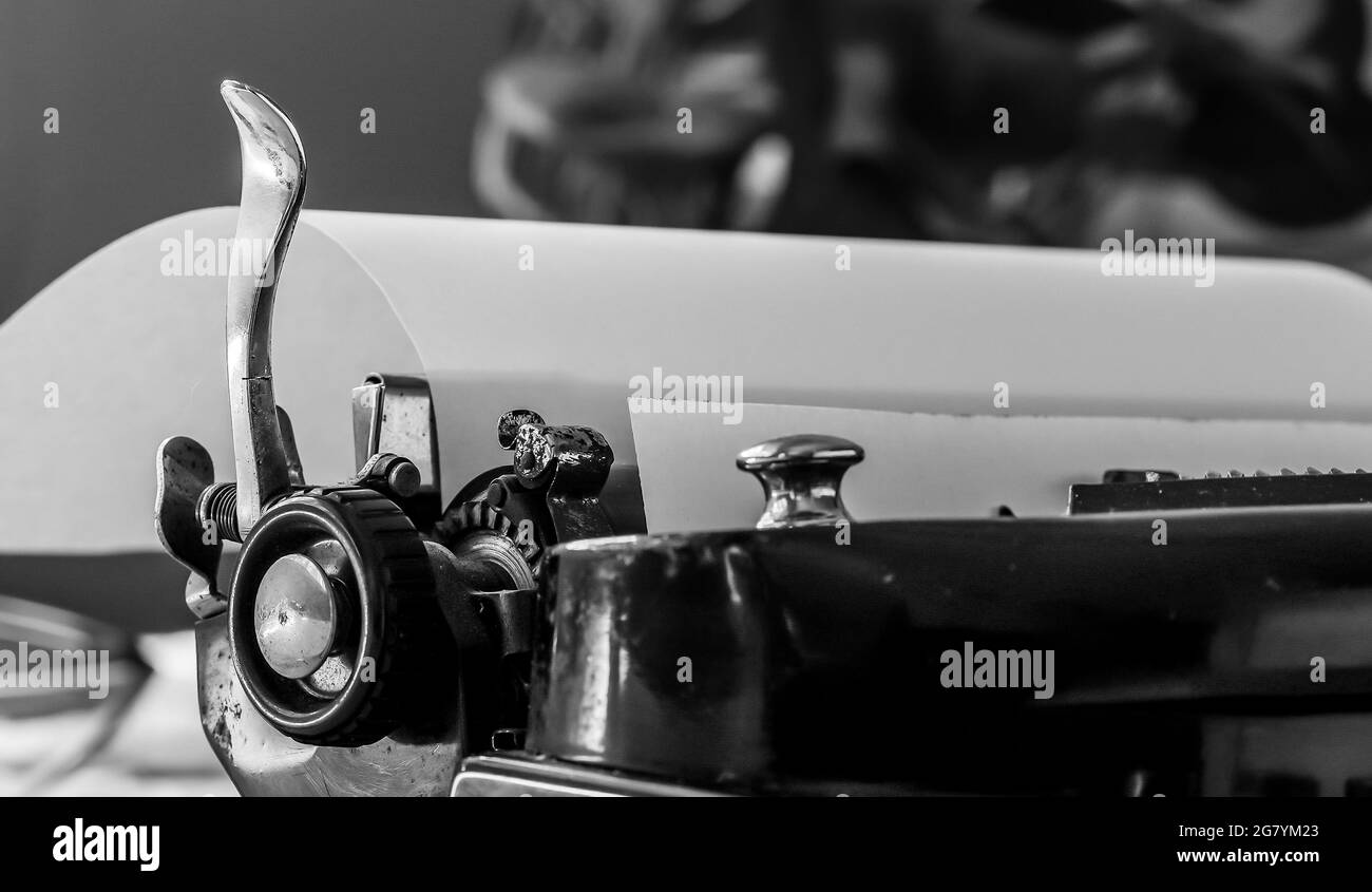 Detail aus alter rostiger mechanischer Schreibmaschine mit Papier innen in schwarz und weiß Stockfoto