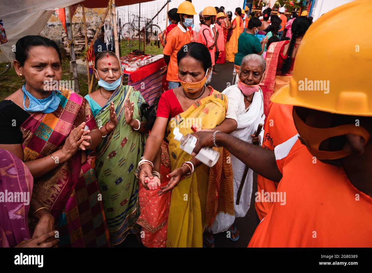 Das Ratha Yatra-Fest wurde im Tempel in Tehatta gemäß den Verwaltungsregeln für Vorsichtsmaßnahmen gegen das Coronavirus gefeiert. Sie durften nicht ohne Masken eintreten. Eine freiwillige Organisation half mit Desinfektionsmittel für die Anhänger. Obwohl es Regeln gab, trugen einige Kinder und Ältere keine Masken oder trugen die Masken nicht richtig. Tehatta, Westbengalen; Indien. Stockfoto Das Ratha Yatra-Fest wurde im Tempel in Tehatta gemäß den Verwaltungsregeln für Vorsichtsmaßnahmen gegen das Coronavirus gefeiert. Sie durften nicht ohne Masken eintreten. Eine freiwillige Organisation half mit Desinfektionsmittel für die Anhänger. Obwohl es Regeln gab, trugen einige Kinder und Ältere keine Masken oder trugen die Masken nicht richtig. Tehatta, Westbengalen; Indien. Stockfoto