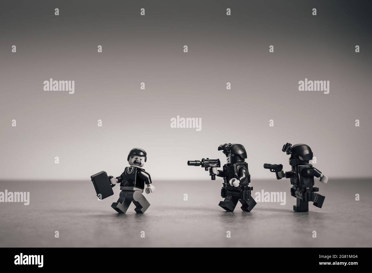 Polizeikommando verfolgt einen Geschäftsmann. Geschäftsmetapher. Illustratives Editorial. 15. Juli 2021 Stockfoto