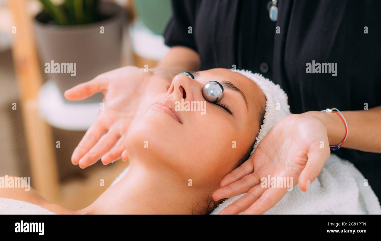 Gesichtsmassage mit chinesischen Meditationskugeln Stockfoto
