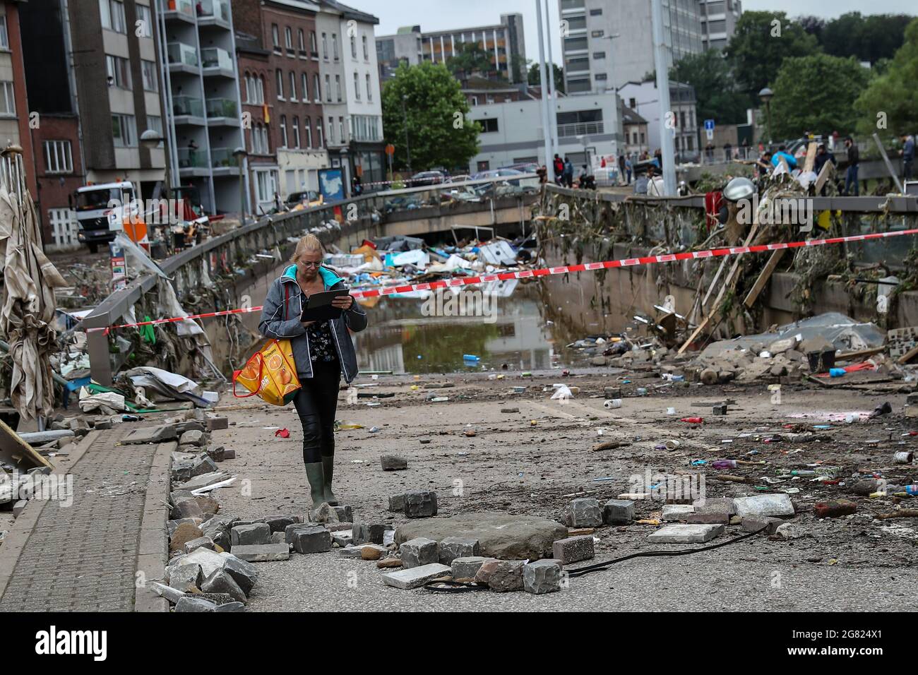 Verviers, Belgien. Juli 2021. Eine Frau geht nach den Überschwemmungen in Verviers, Belgien, am 16. Juli 2021 an einem mit Müll gefüllten Tunnel vorbei. Belgien hat den 20. Juli zum nationalen Trauertag für die Opfer des Unwetters der letzten Tage erklärt. 21 Menschen starben und 18 wurden am Freitag nach Sturzfluten, bei denen Flüsse an ihren Ufern im Süden und Osten des Landes platzten, als vermisst gemeldet. Quelle: Zhang Cheng/Xinhua/Alamy Live News Stockfoto