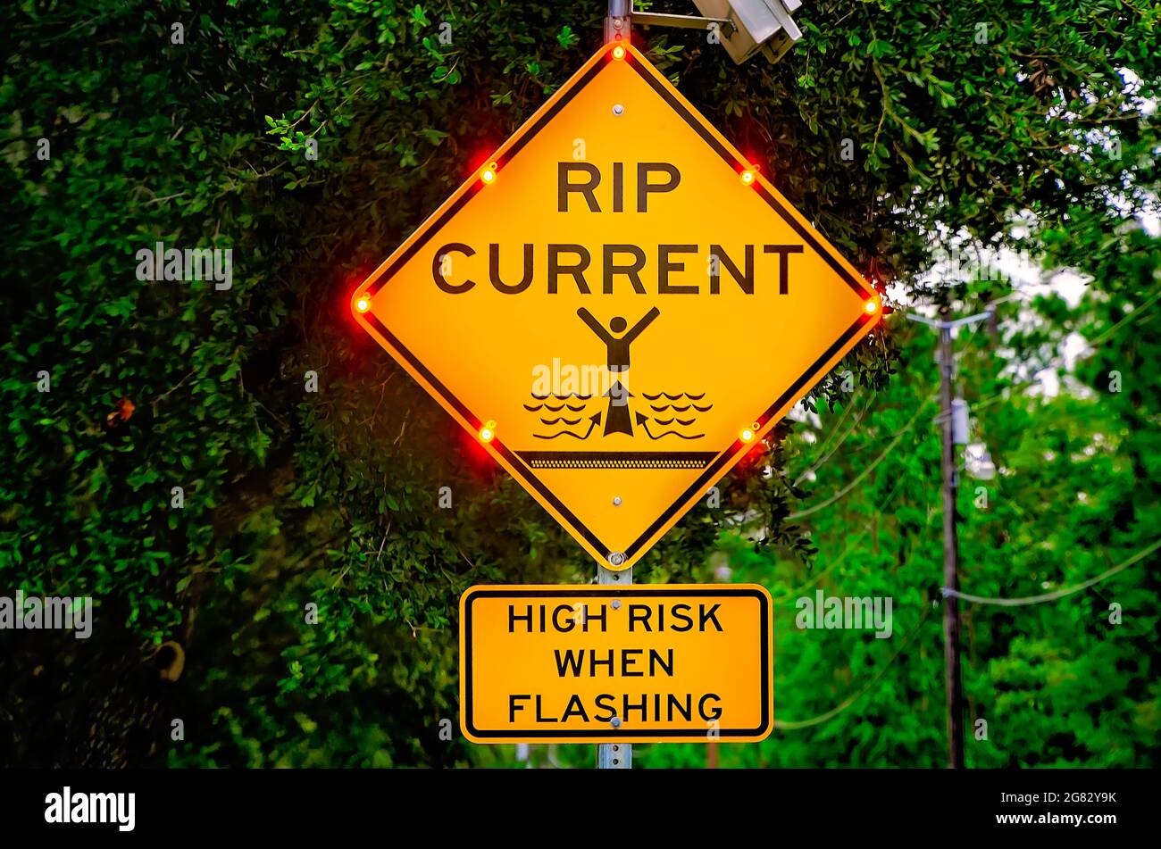 Am 7. Juli 2021 in Dauphin Island, Alabama, blinkt ein Schild mit Stromreißern, um die Besucher vor einem hohen Risiko von Stromreißströmen zu warnen. Stockfoto
