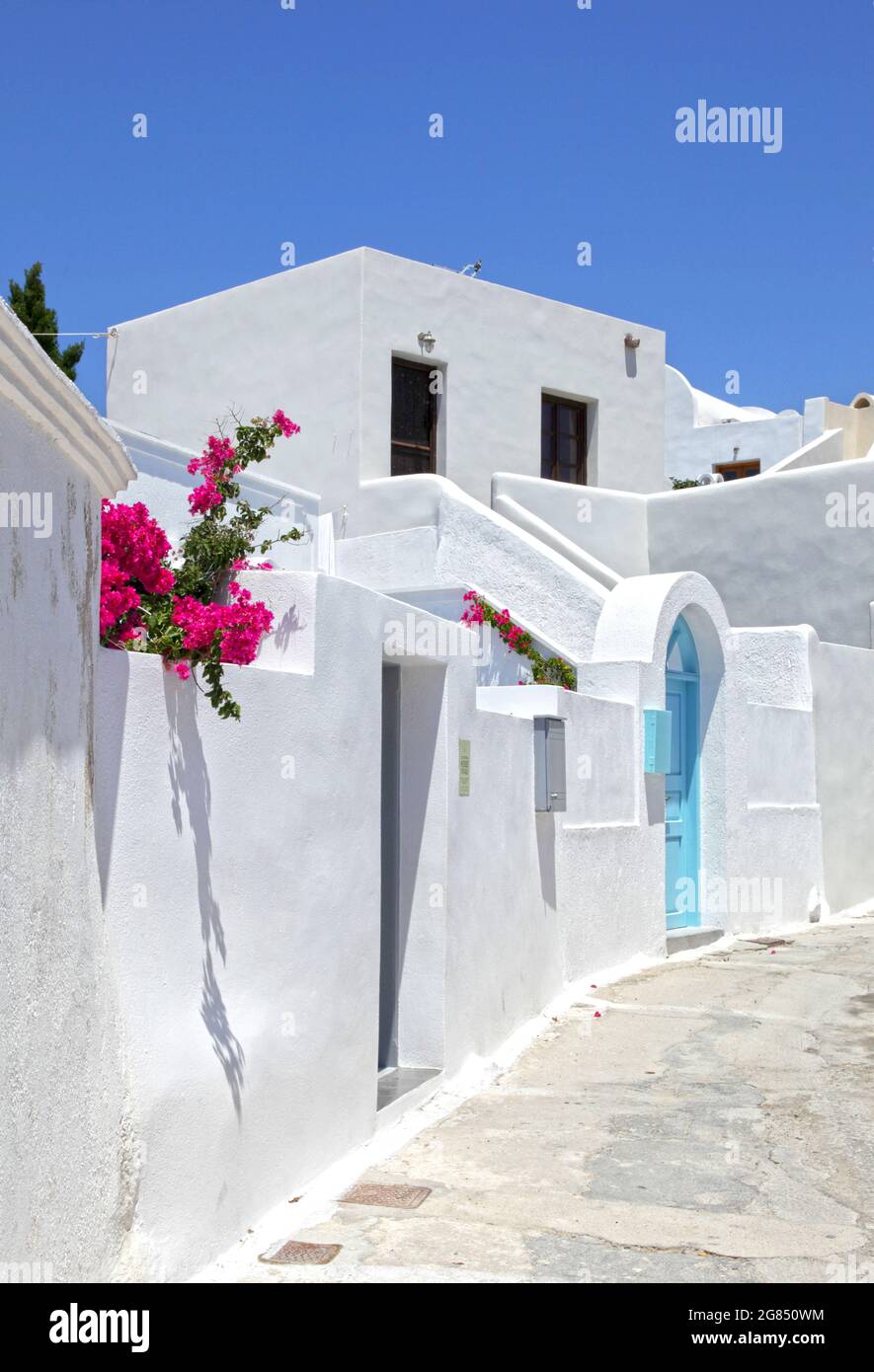 Weiße Wände mit einer blauen Tür im traditionellen Dorf Megalochori, Santorini, Griechenland. Stockfoto