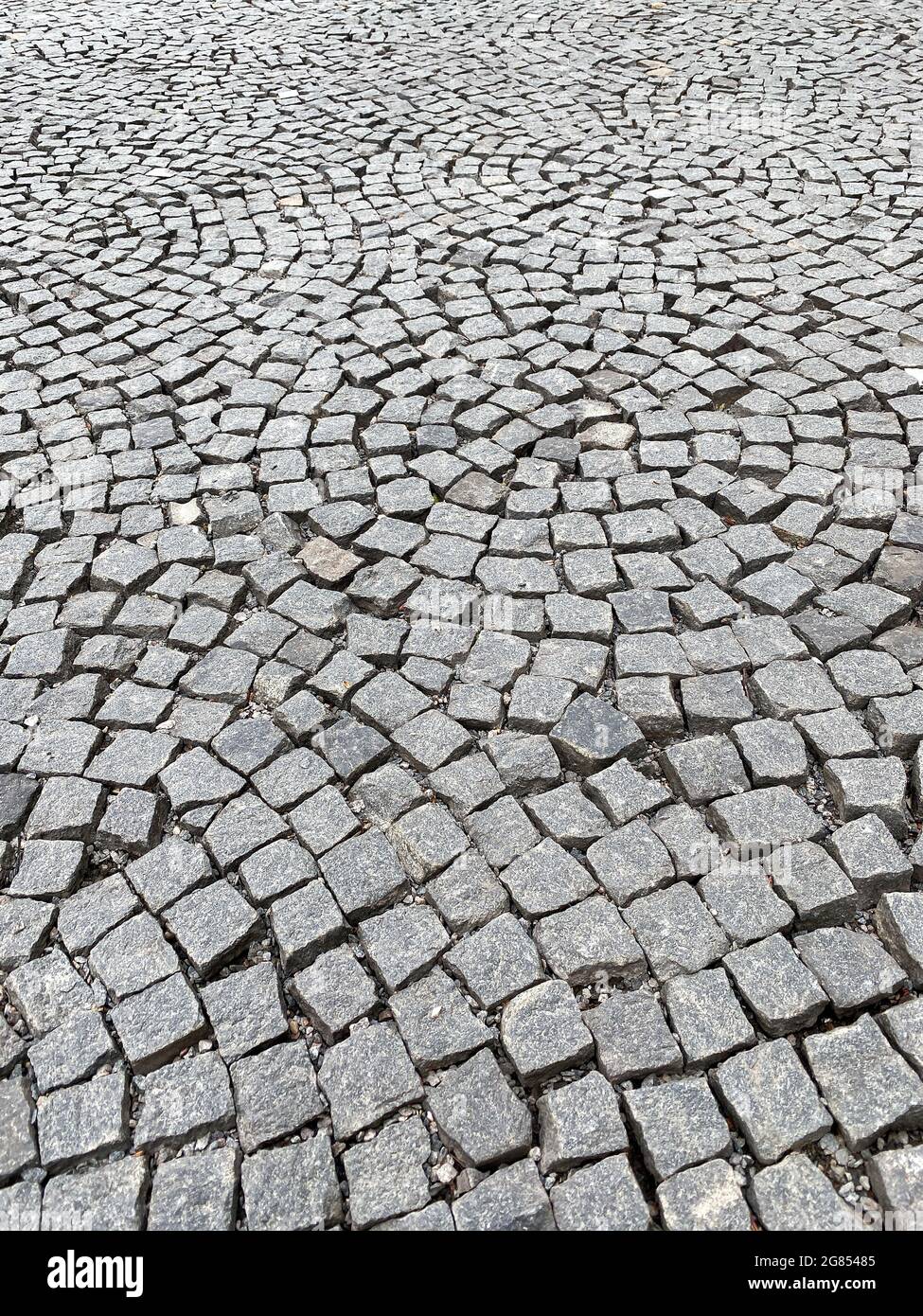Granitpflaster mit kreisförmigem Muster. Abstrakter Straßenhintergrund. Stockfoto