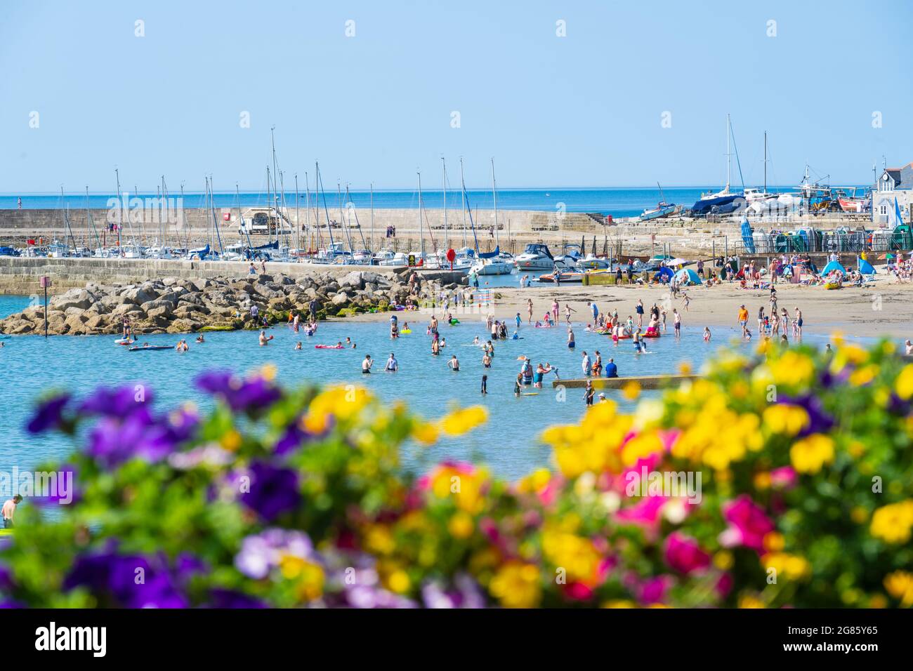 Lyme Regis, Dorset, Großbritannien. Juli 2021. UK Wetter: Ein herrlicher sonniger Start in den Tag Sonnenschein im Badeort Lyme Regis. Der hübsche Strand ist bereits vor 10 Uhr morgens voll. Kredit: Celia McMahon/Alamy Live Nachrichten Stockfoto